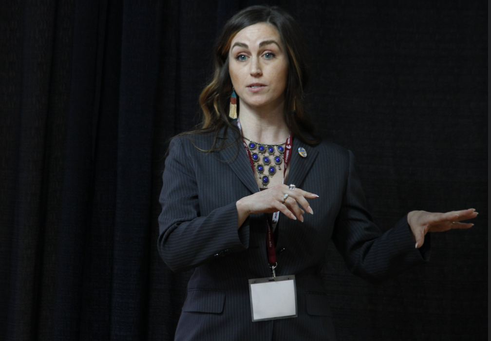 A student emotes with her arms while giving her 3-minute thesis speech.