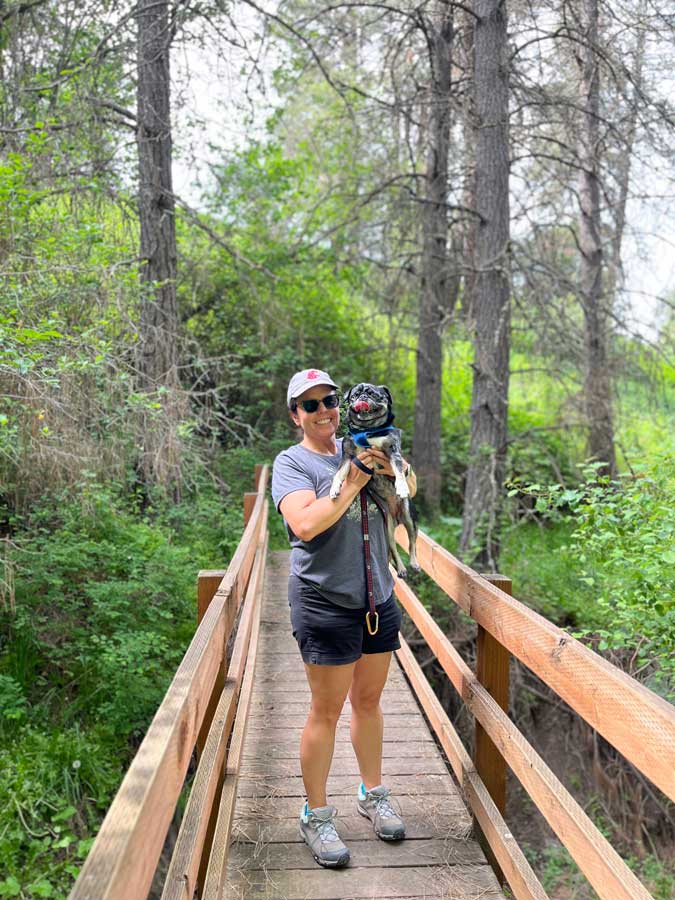 Colette Casavant holds a dog on a bridge.