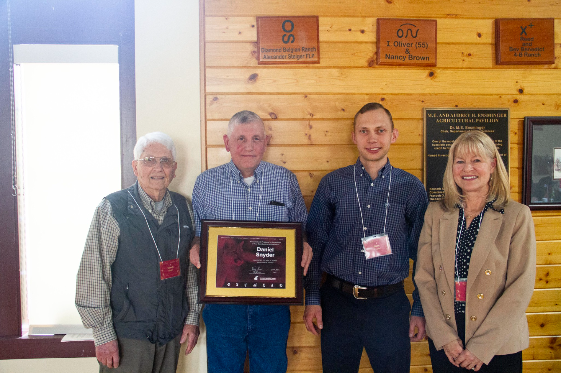 A photograph of Everett Martin, a former professor at WSU, Daniel Snyder, recipient of 2024's Classified Technical Staff Excellence Award, Blake Foraker, and the SSAP Associate Dean, Nancy Deringer pose for a photo with Dan's award. 