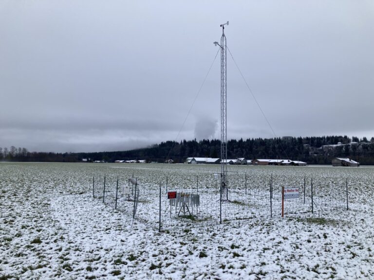 the AgWeatherNet station in winter, with snow on the ground and ominous clouds in the background.