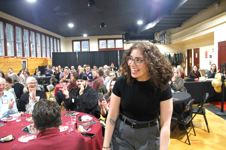 A student jumps up excitedly to receive her award at the banquet for student awards 2024.