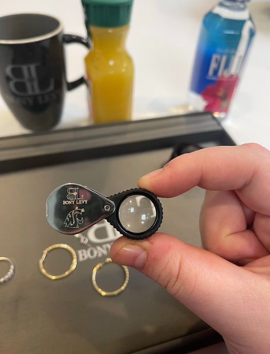 Emily Libey holds a special magnifying glass with an engraving on it that says Bon Levy along with a WSU Cougar logo.