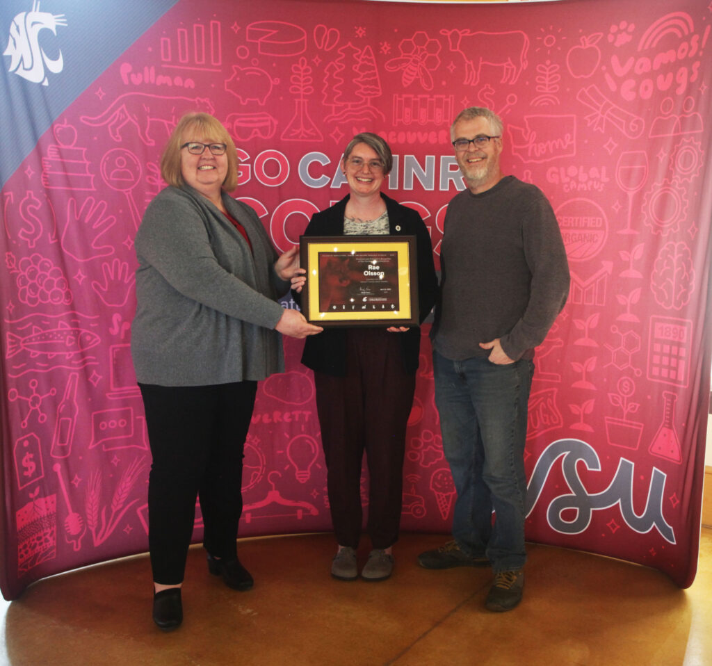 Rae Olsson receiving their award from Dean Powers.