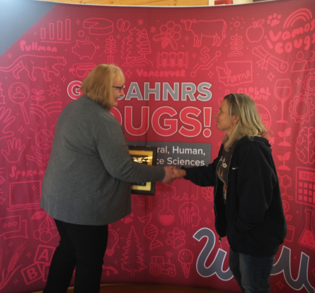 Liz Mieirs shaking Dean Wendy Powers's hand while receiving her award.