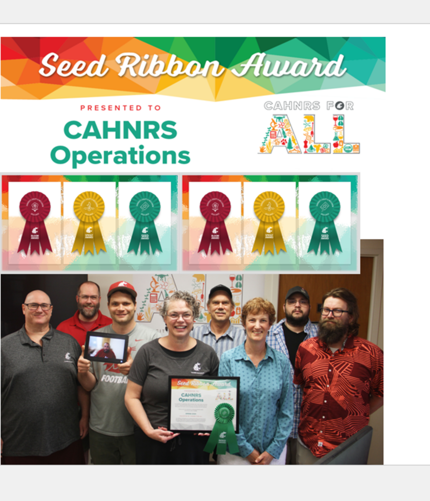 The CAHNRS Operations team poses with their award, one of the members joining virtually through an Ipad for the picture. In the background is the CAHNRS For All banner.