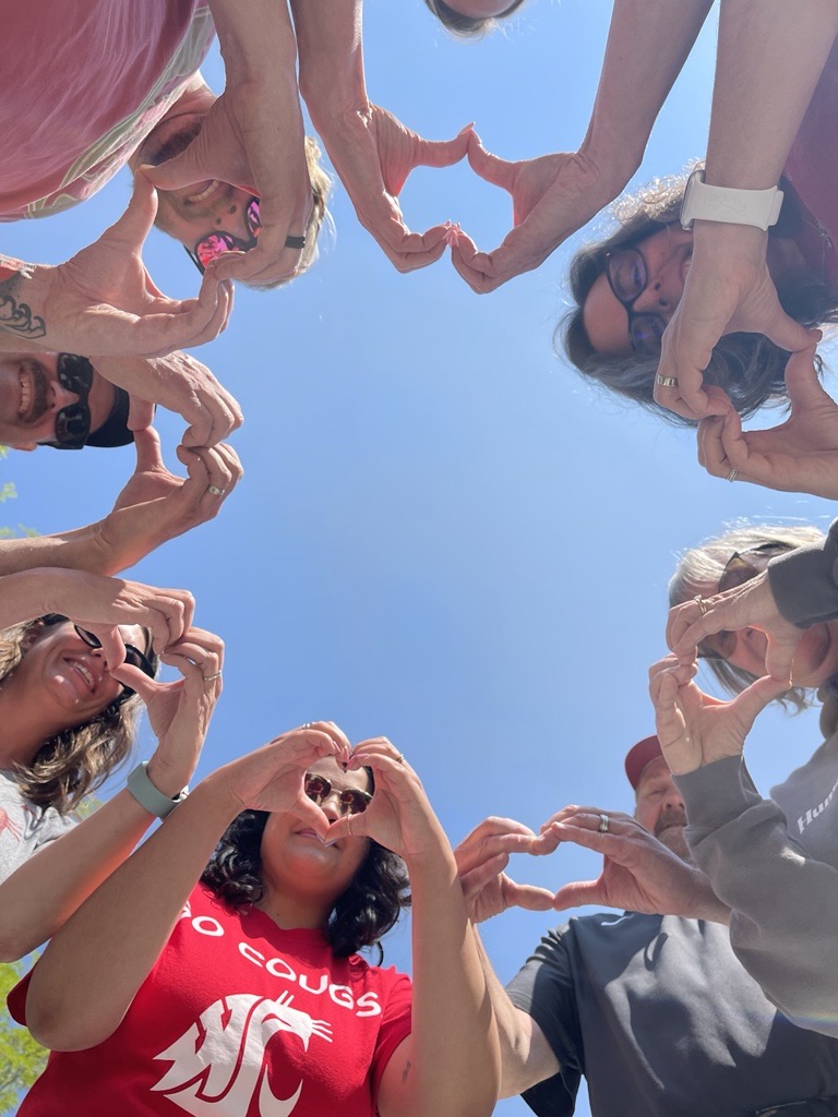 CAHNRS Advisors standing in a circle making hearts with their hands.