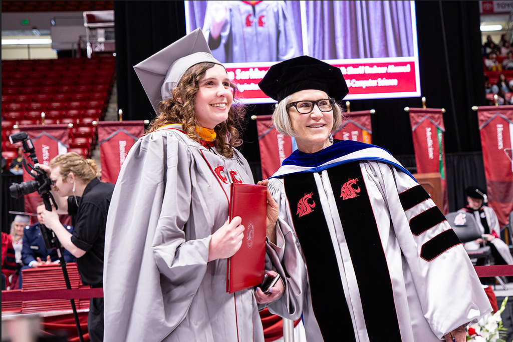 President Elizabeth Cantwell poses with a student receiving their degree.