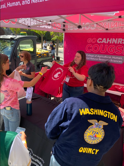 Emily Libey hands out t-shirts to FFA students.