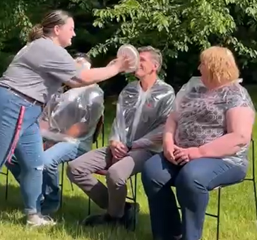 Scot Hulbert smiling as the whipped cream plate is about to get him in the face.