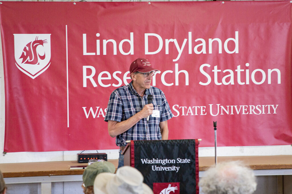 The Acting Dean, Scot Hulbert, speaks to the group in front of a podium on Lind Field Day.