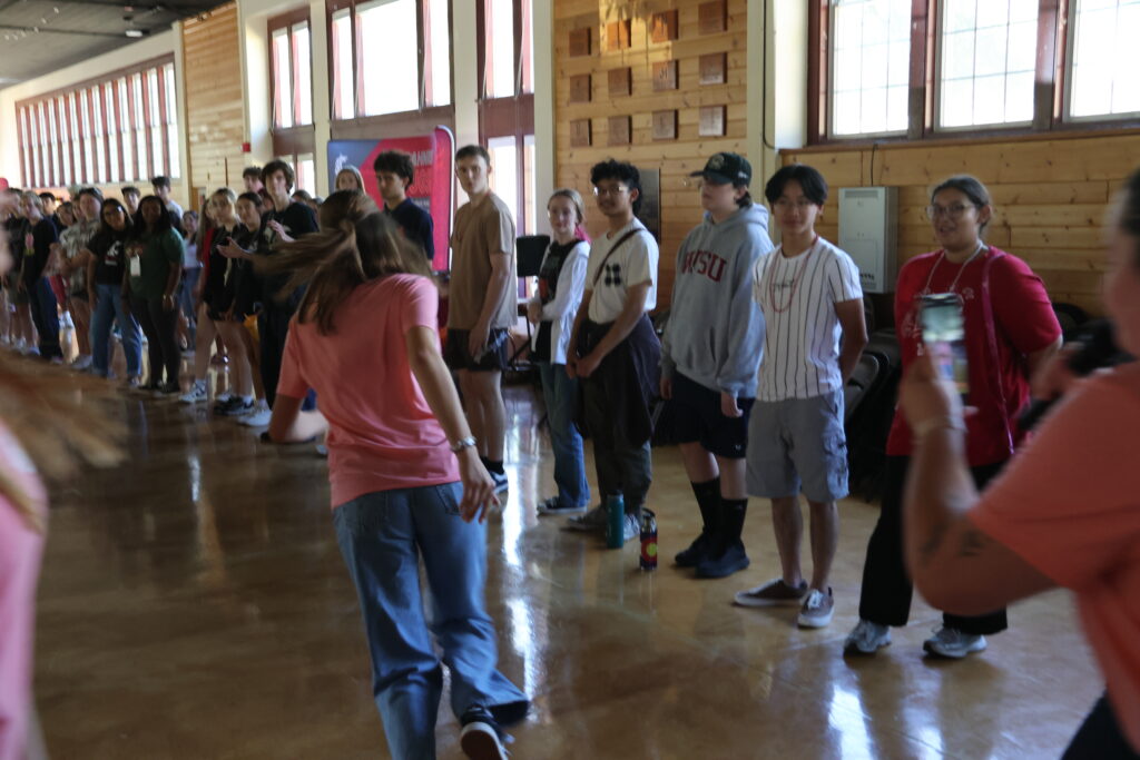 Students run down the middle of the two lines of students for a fun TikTok video.