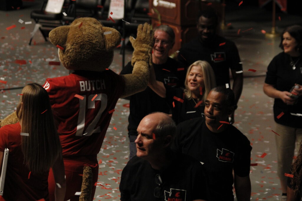 Nancy Deringer high fives Butch at the Commencement ceremony.