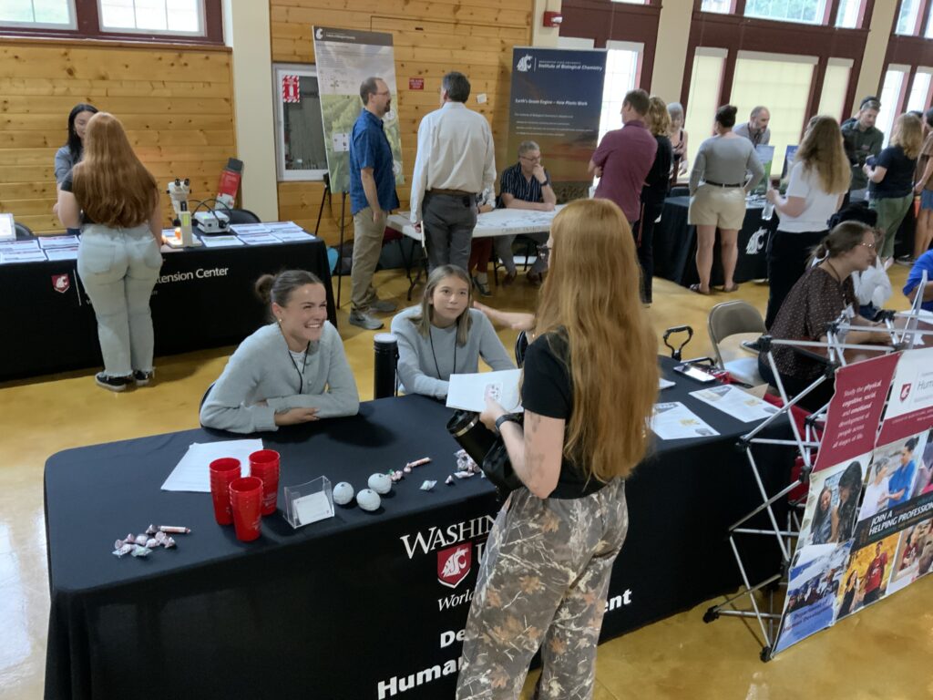 a student talks to HD representatives at a booth at the Science and Research Fair
