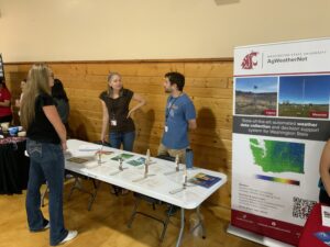 Ag Weathernet representatives chat with a student at their booth for the Science and Research Fair