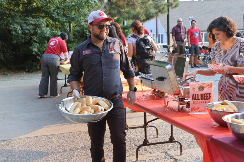 Jacob Moya delivers more hot dog buns to the food tables, looking e