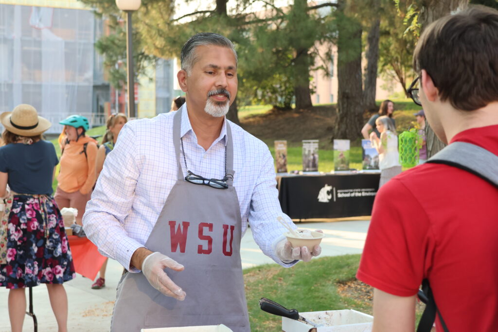 Dean Raj Khosla hands a student ice cream at the Fall Festival