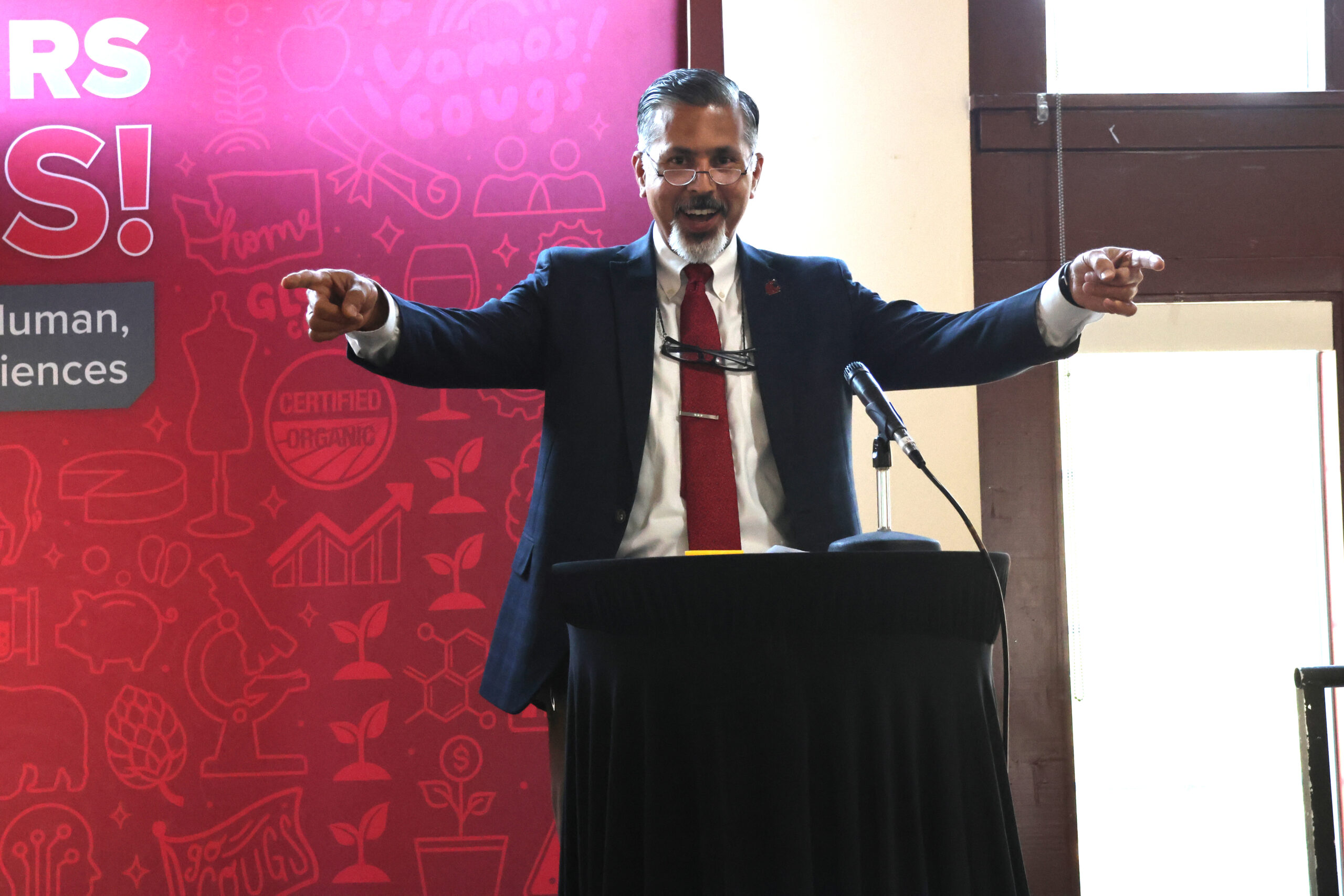 Dean Raj Khosla points excitedly while giving an opening address at the Top Scholars Orientation Dinner