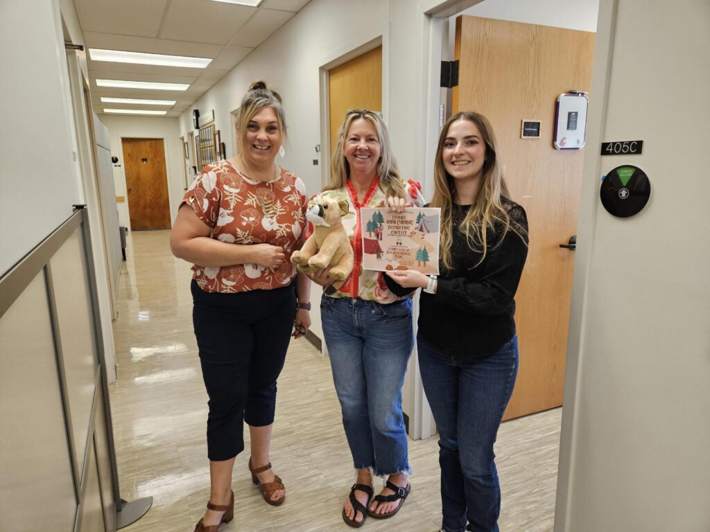 Jolene Knight and Lesa Neumman accept their prize for winning the homecoming decorating contest, which is a cougar plushie and a certificate signed by Nancy Deringer