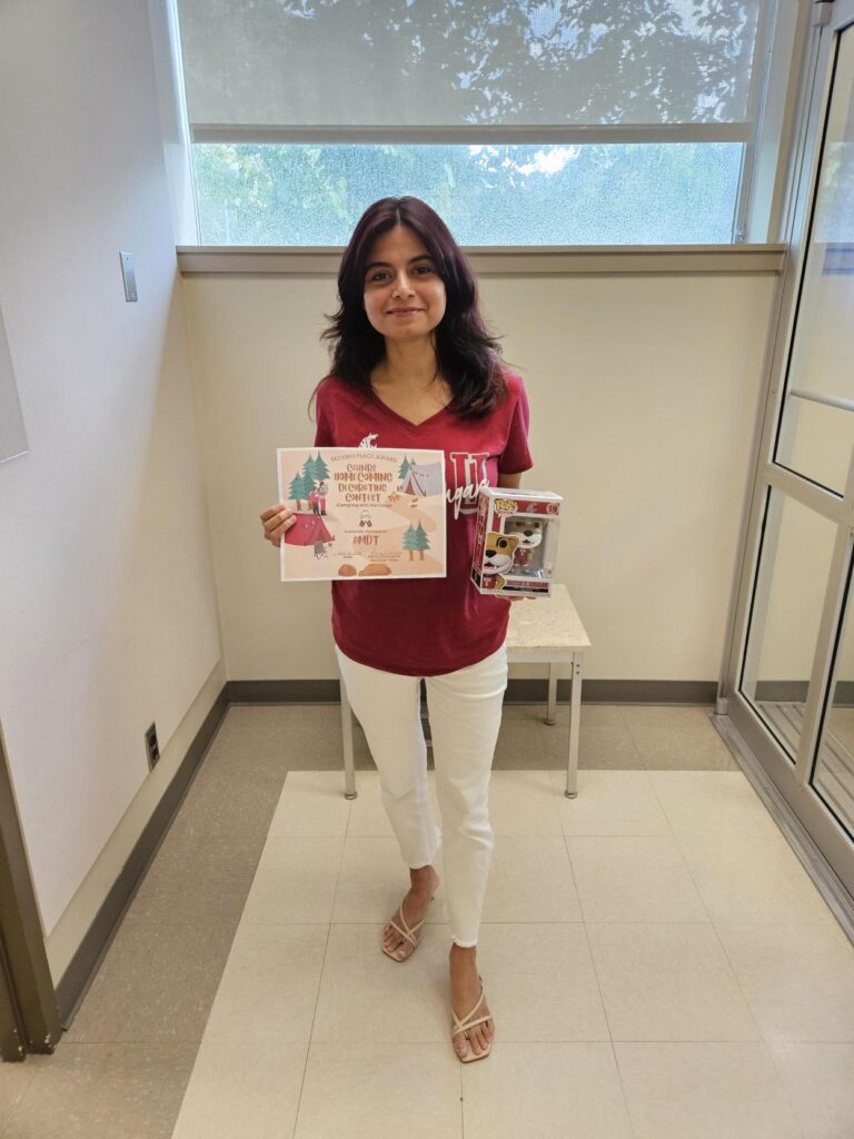 Arpita from AMDT holds the certificate for second place along with a cougar bobblehead prize.