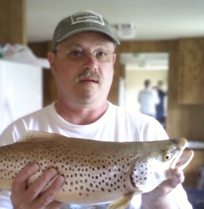 Richard Sharpe holds up a fish.