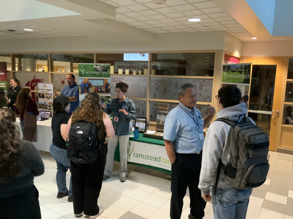 Students mingle in front of the Ramstead Ranch booth at CAHNRS Networking Night.
