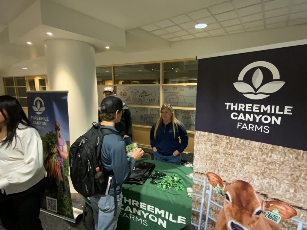 A ThreeMile Canyon Farms representative talks with a student at her Career Fair booth