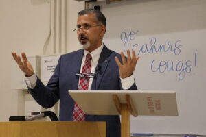 Dean Khosla presents in a Cougar Crimson and Gray tartan tie with the words "Go CAHNRS Cougs!" written on the whiteboard behind him.