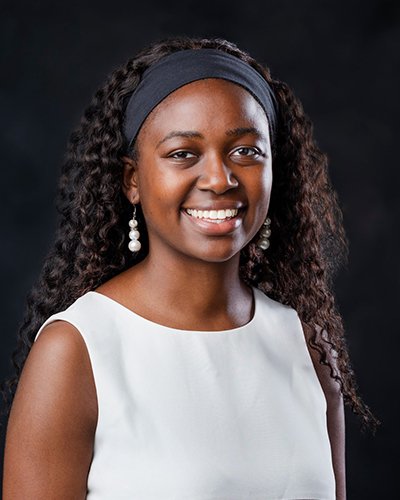 Angella Osinde's headshot dressed in professional attire, smiling.