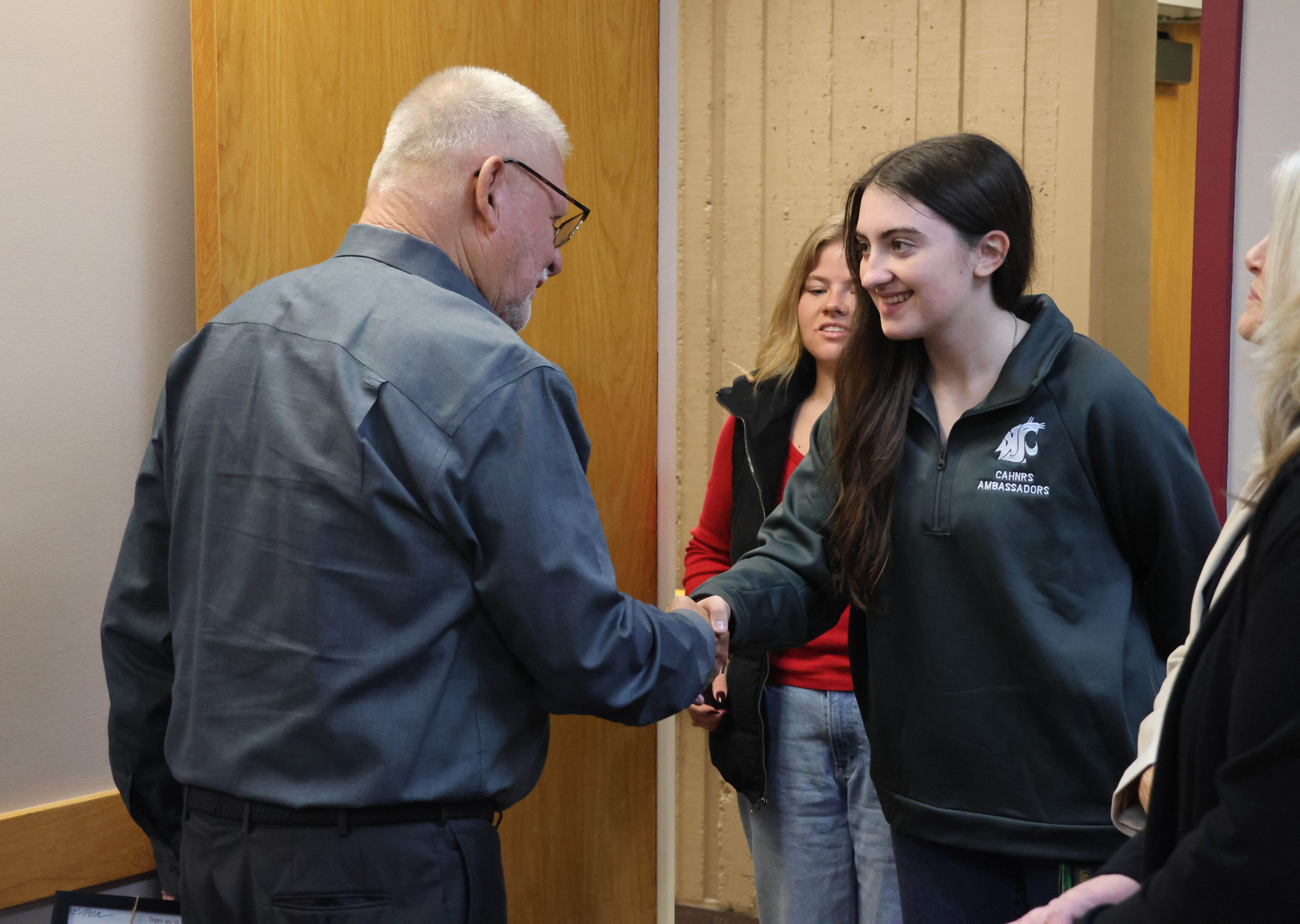 Gordon Davis shakes hands with Elyssa, a CAHNRS student Ambassador.