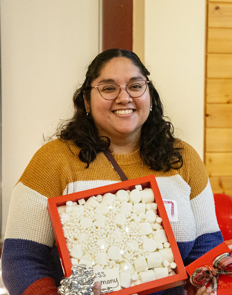 The winner of this year's candy jar guessing activity, the marshmallo box, beams brightly while receiving her prize.