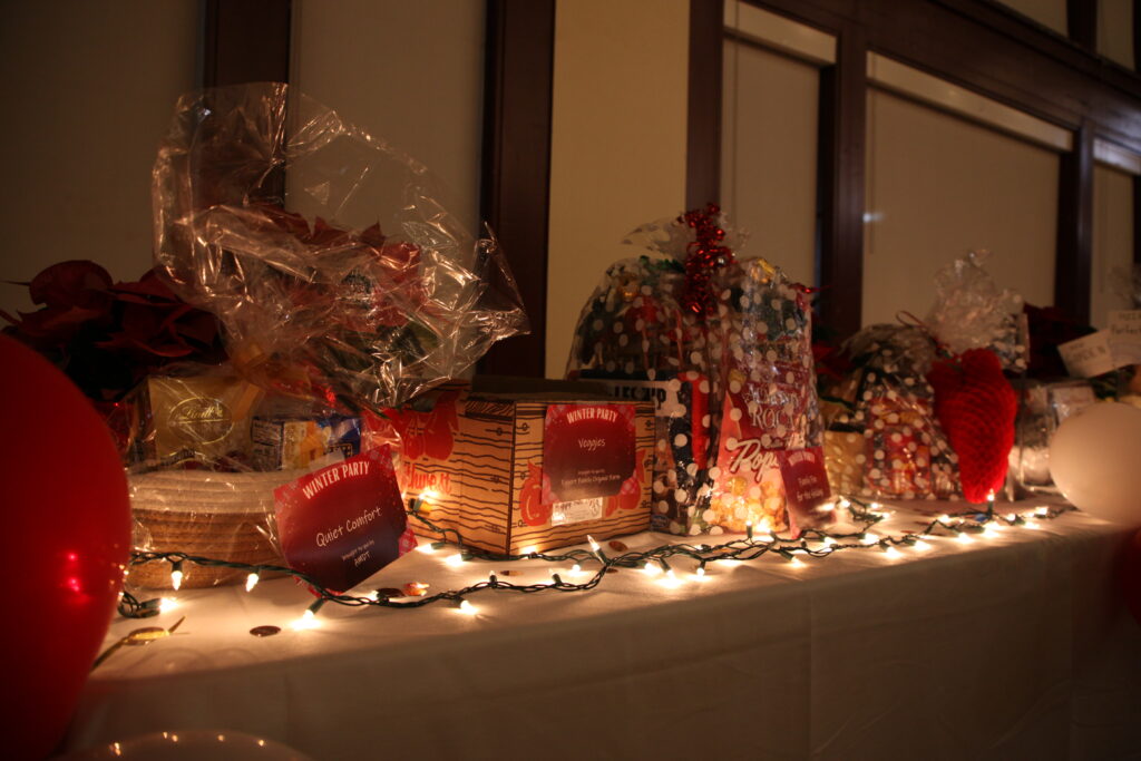 The gift raffle table features clear wrapped baskets with polka dots and beautiful christmas lights. 