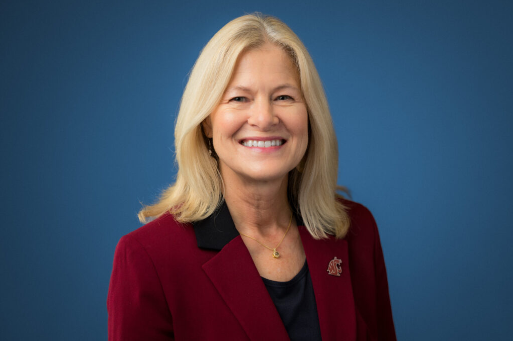 Nancy Deringer wears a crimson blazer with a WSU logo pin.