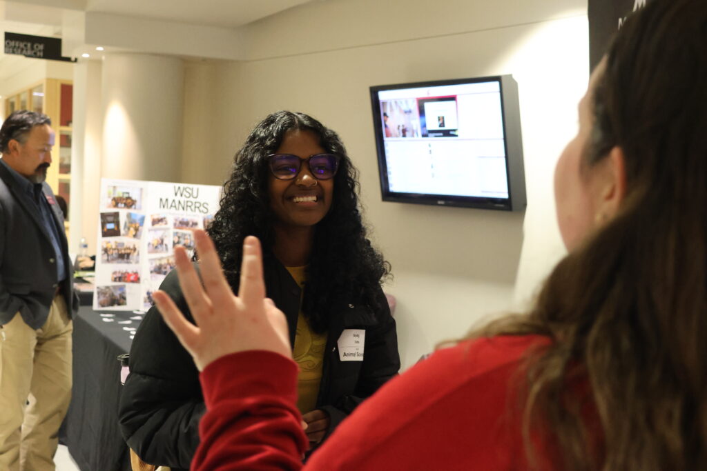 A staff representative directs an attendee of Networking Night for a Tiktok the attendee has volunteered to star in.