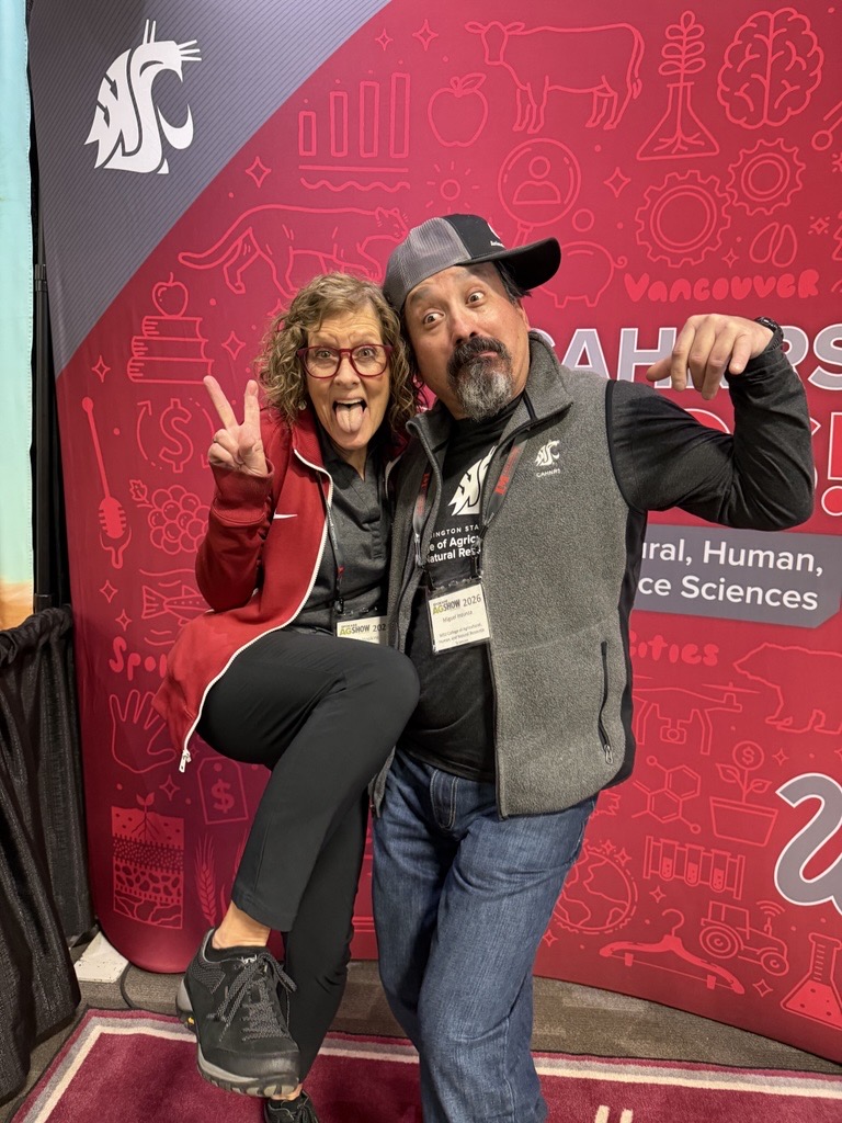 Miguel Inzunza and Judy Hopkins make a very silly pose, with a sideways hat and a peace sign.