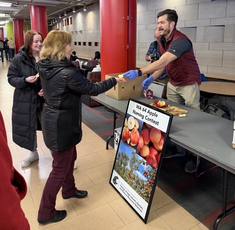 Britta Nitcy, a CAHNRS employee, receives an apple from the Director of Commercialization at the Apple tasting event.
