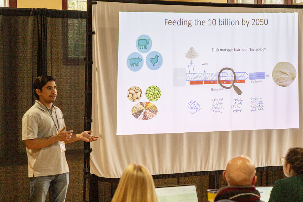 3MT presenter with his presentation  slide called "Feeding the 10 Billion by 2050"