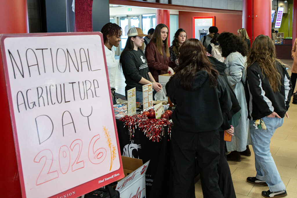 National Ag Day invite sign and student ambassadors running the booths.