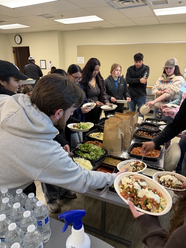 Students reach for yummy food at a CAHNRS Ambassadors meeting.