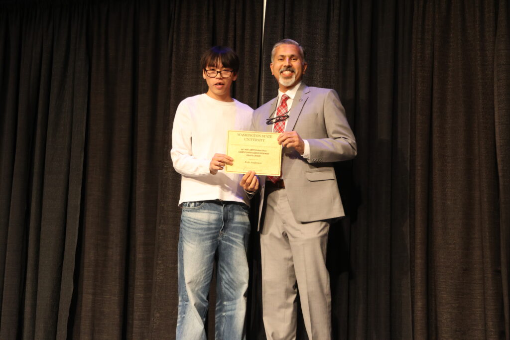 WSU student being handed a certificate from Dean Khosla, at the fashion show.
