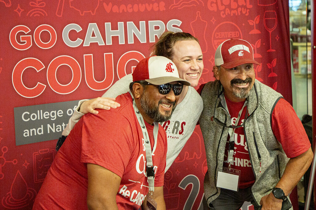 Three people in Coug gear smiling at the camera