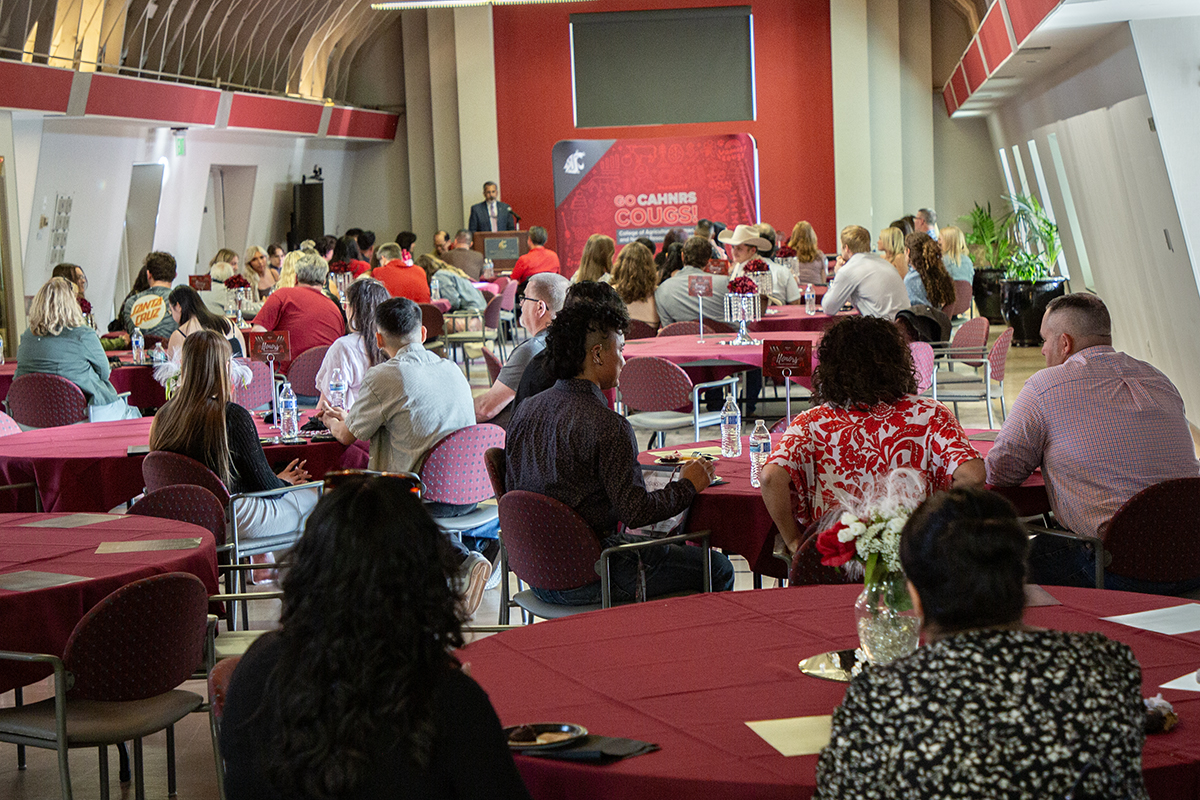 Crimson tables full of honorees and families at a desserts banquet for Dean's Honor Roll students celebration