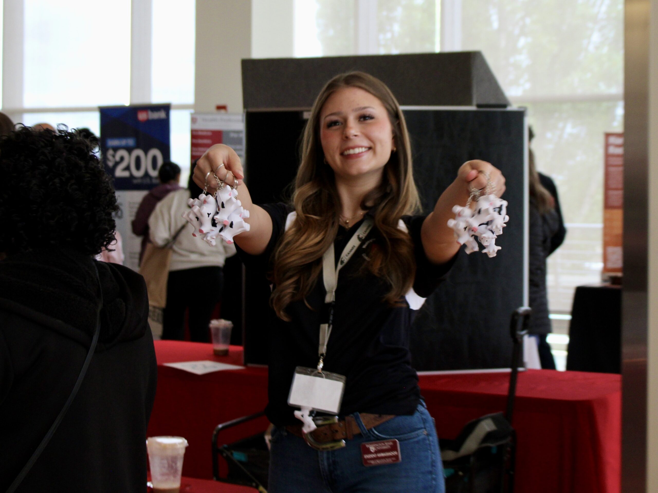 Student Employee Addison Jackson hands out miniature cow keychains to students at New Coug Orientation