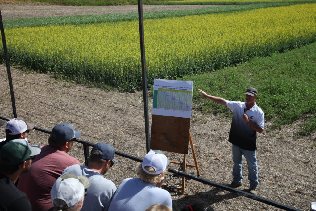 Aaron Esser presenting in front of crop trials at the Wilke field day.