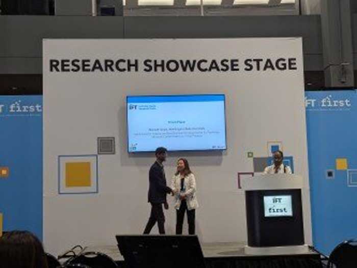 Rishabh Goyal accepting an award on stage for Research Showcase.