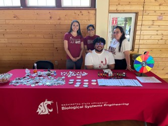 Group of four people standing at a table with swag.