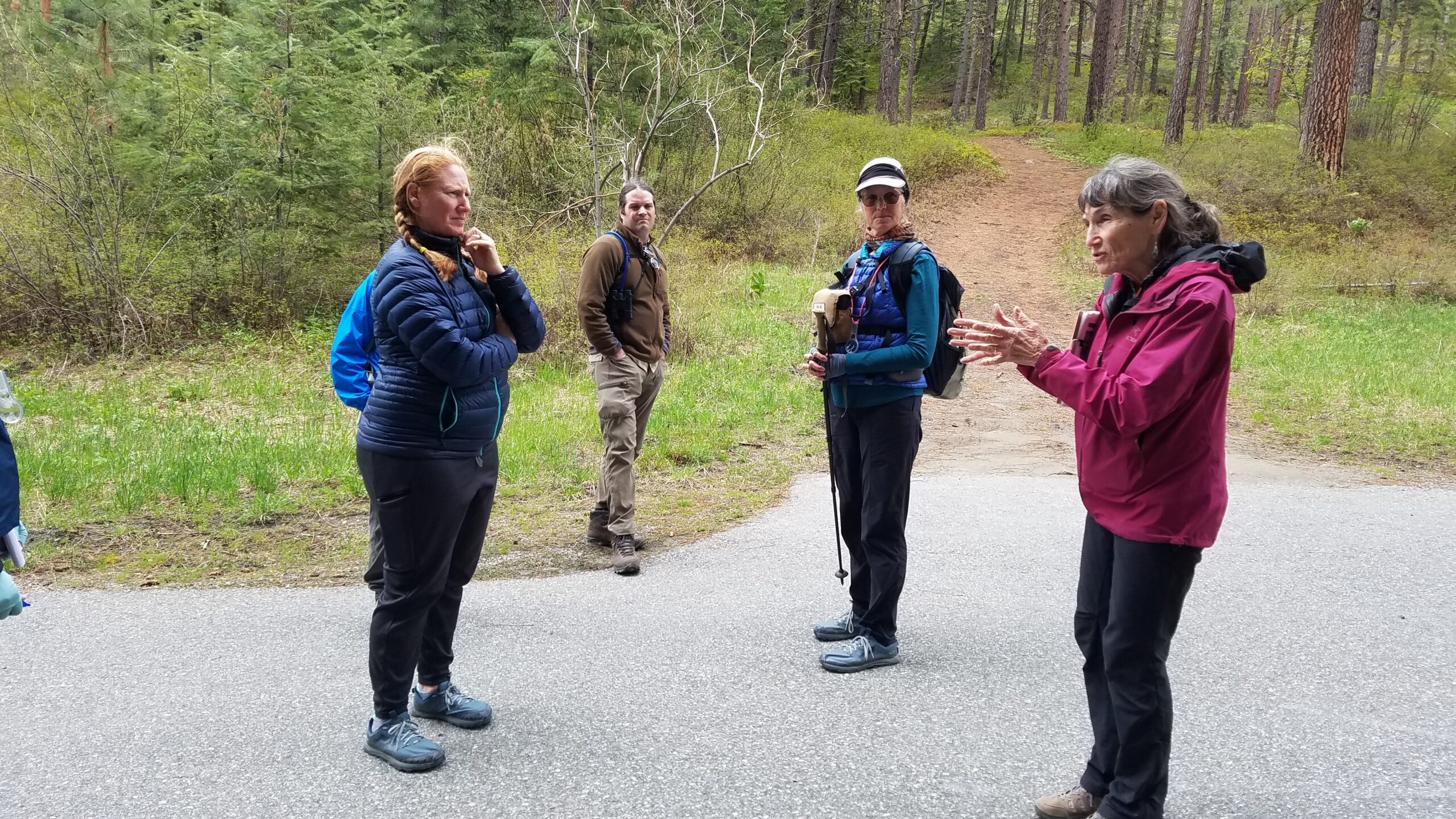A group of Washington State Naturalists on a paved trail learning from a tour leader.
