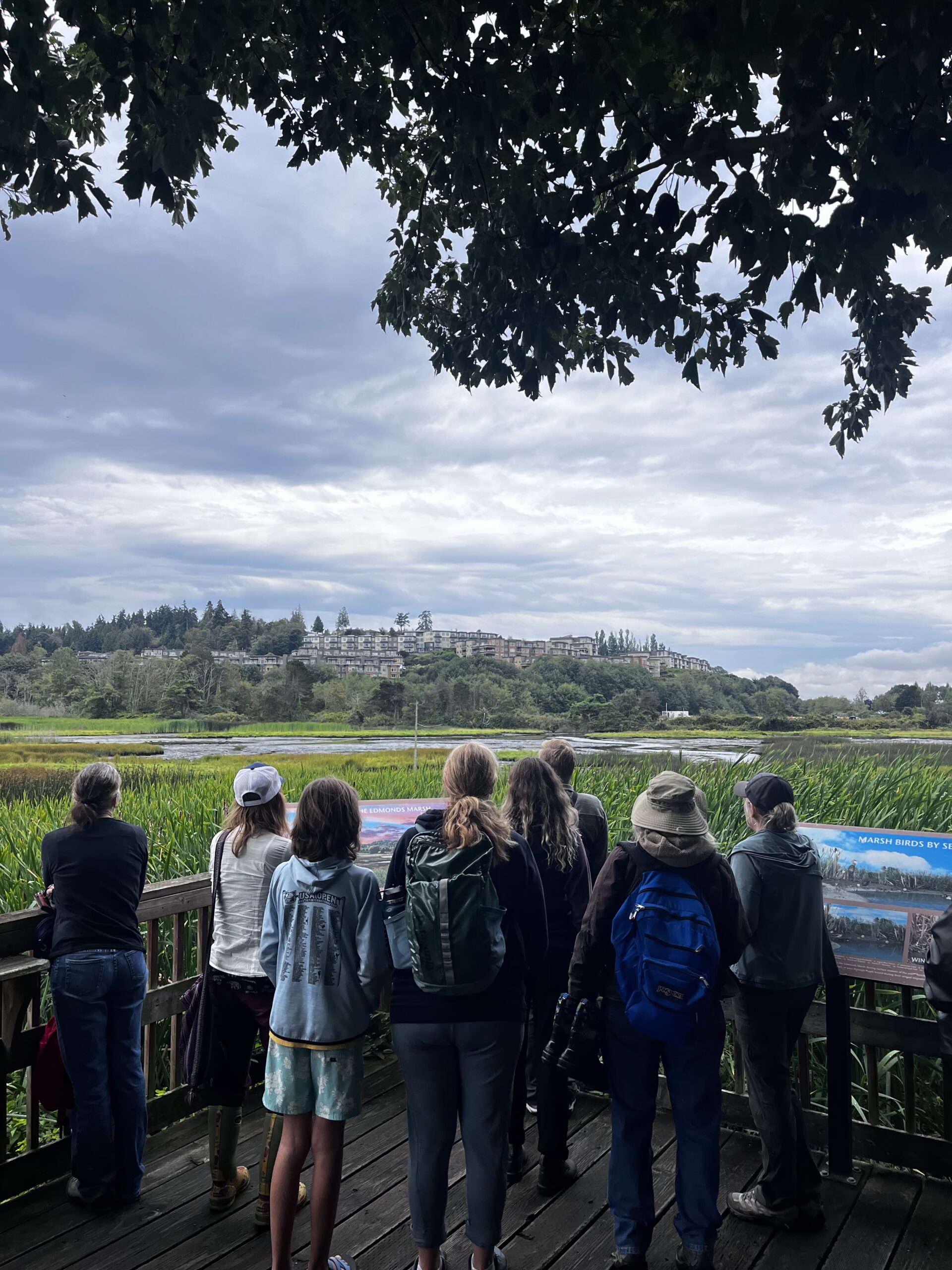 A group of naturalist students on a gravel road in a prairie