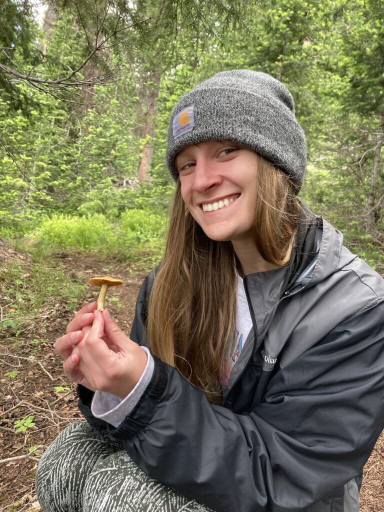 Woman in a forest holding a mushroom