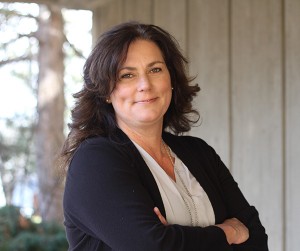 A portrait of a brunette woman in a black cardigan.