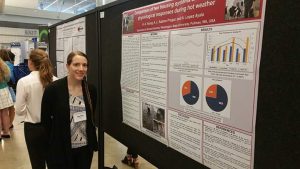 Heather Young stand next to poster with statistical graphics on it.